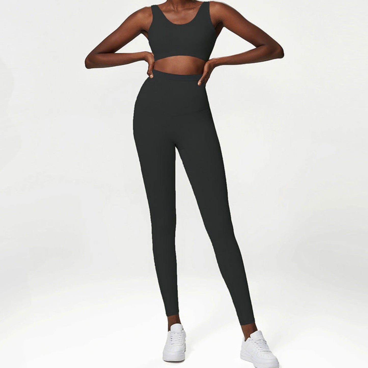 African American model wearing a black, high waisted, squat proof matching workout set from Vibras Activewear.