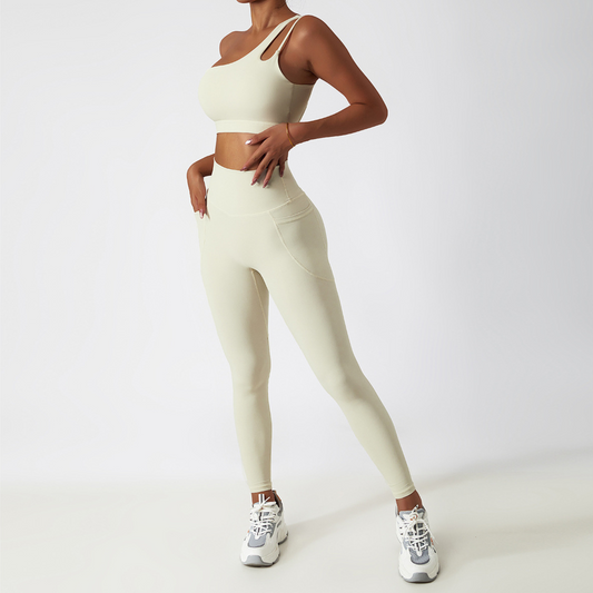 Fitness model wearing a one shoulder, sexy and squat proof matching set in the colour cream from vibras activewear.