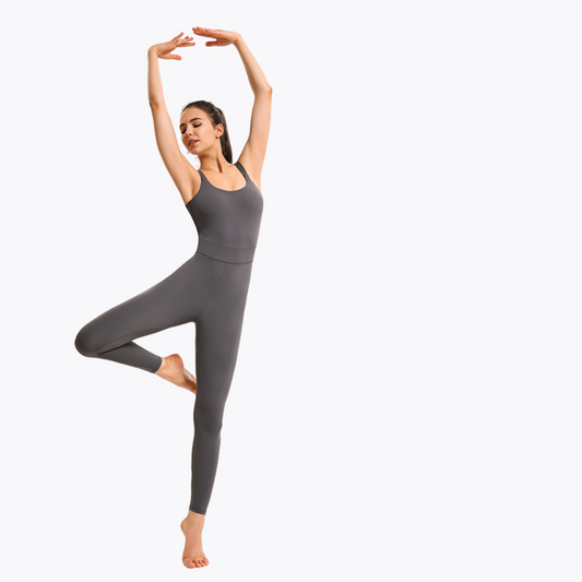 PHOTO OF A FITNESS MODEL DANCING BALLET WEARING A GREY JUMPSUIT FROM VIBRAS ACTIVEWEAR ON A WHITE BACKGROUND.